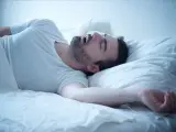 Mann schläft tief und schnarcht, was auf Schlafapnoe hindeuten kann. Hausmittel können hier Abhilfe schaffen.