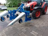 Niebieska kosiarka do fasoli marki SOCHMET, zamontowana z tyłu czerwnego traktora Kubota, gotowa do pracy na polu.