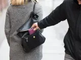 Ręka wyciąga portfel z torebki kobiety. Czy to kradzież, czy objaw kleptomanii?