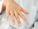 Una mano con algunas manchas, incluyendo un lunar visible en el dorso.