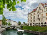 Lublana co zobaczyć: malowniczy widok na rzekę Ljubljanicę, most i zabytkowe budynki. Rejs statkiem to świetny sposób na zwiedzanie.