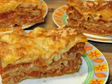 Prosty przepis na lasagne z mięsem mielonym. Aromatyczne, warstwowe danie z makaronem, sosem mięsnym i serem, podane na kolorowych talerzach.