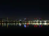 Nocny widok na Seul z rzeką Han, mostem i wieżą Namsan. Światła miasta odbijają się w wodzie, tworząc magiczny krajobraz. Itaewon tętni życiem.