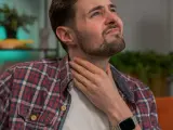 Mann mit Hand am Hals, besorgt über die Lebenserwartung nach Kehlkopfentfernung.