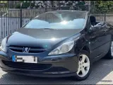 Svart Peugeot 307 CC cabriolet, taket nere. Solen reflekteras i lacken, kanske ett tecken på ett kommande problem?