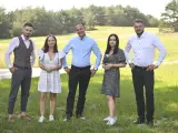 Uczestnicy programu "Rolnik szuka żony 10" pozują na tle zielonej łąki.