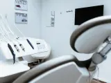 Gabinet stomatologiczny z fotelem i narzędziami. W tle monitor i lustro. Czystość i sterylność, jak po użyciu środka z chlorheksydyny diglukonianem.
