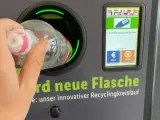 Ręka wrzuca butelkę do automatu. Niemiecki system kaucyjny działa sprawnie, zwracając 0,25 EUR za każdy zwrot.