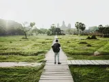 Chłopiec z plecakiem idzie ścieżką do Angkor Wat, jednego z cudów największego kontynentu na ziemi.