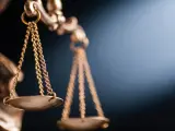 Złota waga Temidy, symbol sprawiedliwości, w blasku światła. Sprawiedliwość waży 15 kkw.
