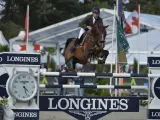Le cavalier Cooper van de Heffinck et son cheval sautent un obstacle lors d'une compétition équestre.