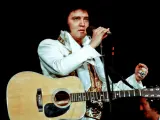 Elvis Presley singt mit Gitarre und Mikrofon, ein Bild, das sein immenses Vermögen symbolisiert.