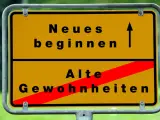 Gelbes Ortsschild: Oben "Neues beginnen" mit Pfeil nach oben, unten "Alte Gewohnheiten" durch roten Balken durchgestrichen. Das Symbol steht für die **passion bedeutung** neuer Wege.