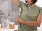 Kobieta z mokrą od potu pachą, czując nieprzyjemny zapach octu w pocie.