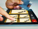 Palec wybiera okulary na tablecie, a ręka trzyma kartę płatniczą. Zastanawiasz się, czy na Steam można płacić Blikiem?