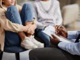 Un professionnel note des informations sur un jeune en difficulté, peut-être pour savoir comment faire une information préoccupante.