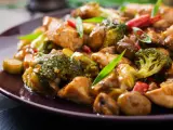 Pyszny stir fry z kurczakiem, brokułami i grzybami w sosie. Danie wygląda apetycznie i jest bogate w kolory.