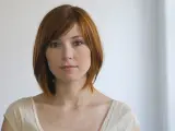 Kobieta z rudymi włosami w stylowym bobie asymetrycznym cieniowanym, z delikatnym uśmiechem.