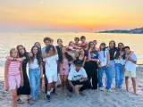 Groupe d'adolescents souriants sur une plage corse au coucher du soleil.