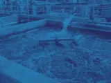 Proces oczyszczania ścieków, gdzie dodawany jest flokulant, tworząc pieniącą się masę w betonowym basenie.