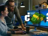 ¿Cuánto cobra un diseñador de videojuegos? Dos personas trabajan en monitores con gráficos de dinero y un signo de interrogación.