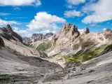 Malownicze **Val di Fassa** w Dolomitach. Kręta ścieżka prowadzi przez skaliste zbocza i zielone hale ku majestatycznym szczytom.