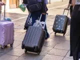 Ludzie z walizkami na kółkach, zastanawiający się, ile dopłata za bagaż Ryanair.
