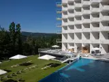 Nowoczesny hotel Crystal Mountain Resort z basenem i leżakami na trawie, otoczony zielonymi wzgórzami.