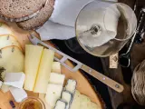 Deska serów z chlebem, winem i akcesoriami. Idealne połączenie, by dowiedzieć się, jakie wino do serów pasuje najlepiej.