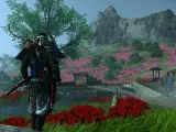 Samuraj w zbroi z łukiem na plecach stoi na tle kwitnącej wiśni. Sceneria z gry Ghost of Tsushima na Xbox.