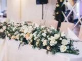 Eleganckie kwiaty na wesele zdobią stół, tworząc romantyczną atmosferę. Bukiet z róż i zieleni.