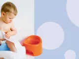 Małe dziecko siedzi na niebieskim nocniku, bawiąc się papierem toaletowym. Kiedy uczyć dziecko na nocnik? Czas zacząć!