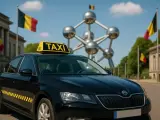 Schwarzer Taxi in Belgien vor dem Atomium. Belgische Flaggen wehen im Hintergrund.
