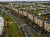 Widok z lotu ptaka na najdłuższy blok w Europie, rozciągający się wzdłuż ruchliwej drogi i otoczony zielenią oraz innymi budynkami mieszkalnymi.