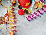 Karneval am Donnerstag: Goldene Maske, bunte Luftschlangen, rote Clownsnase und Konfetti laden zum Feiern ein.
