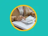 Une personne utilise une calculatrice sur des documents pour apprendre comment payer moins d'impôts.