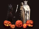 Skrämmande pumpor lyser upp mörkret inför **halloween datum**. En figur med horn och fackla står bredvid statyer av ett kungapar.