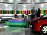 Studio telewizyjne, gdzie nagrywane jest koło fortuny. Widać scenografię z kolorowymi panelami, schodami i czerwonym samochodem.