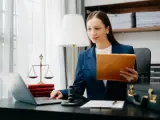 Prawniczka pracuje nad sprawą wdrożenie windykacji, analizując dokumenty na laptopie.