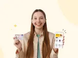 Uśmiechnięta dziewczyna trzyma dowód osobisty i smartfon z aplikacją do zdjęć do dowodu.