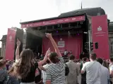 Menschen jubeln bei einem Open-Air-Konzert vor einer Bühne mit Sparkassen-Logo.