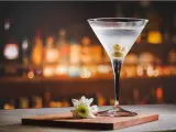 Kryształowy kieliszek z martini, trzema oliwkami i białą kwiatową ozdobą. Idealny drink, z czym pić martini?
