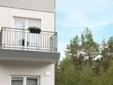 Nowy balkon z kwiatami, z którego roztacza się widok na las. Czy to miejsce wolne od podatku od balkonu?