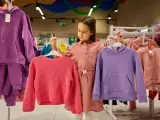 Dziewczynka wybiera ubrania. Czy ten różowy sweterek lub fioletowa bluza to dobry rozmiar dla 7-8 latka?