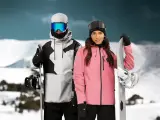 Pareja con tablas de snowboard, ella con chaqueta rosa, él con chaqueta gris y negra. Opiniones sobre Sorona Aura: ¡calidez y estilo en la montaña!