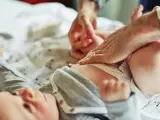 Rodzic zmienia pieluchę noworodkowi. Ile pieluch na miesiąc dla noworodka? To pytanie nurtuje wielu rodziców.
