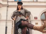 Kobieta w czapce i marynarce w kratę, z nogą uniesioną do przodu. Czy to rozmiar damski 44?