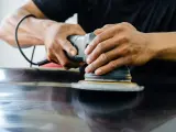 Ręce trzymają polerkę, która wykonuje polerowanie aluminium. Powierzchnia staje się lśniąca.