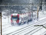 Pociąg w śniegu, mimo strajku maszynistów, jedzie po torach.