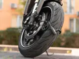 Zabezpieczenie motocykla przed kradzieżą: gruby, czarny łańcuch oplatający oponę i tarczę hamulcową.